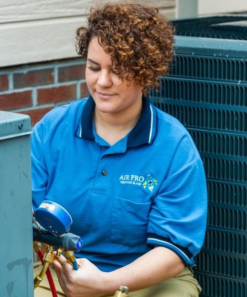 technician inspecting an air conditioning unit