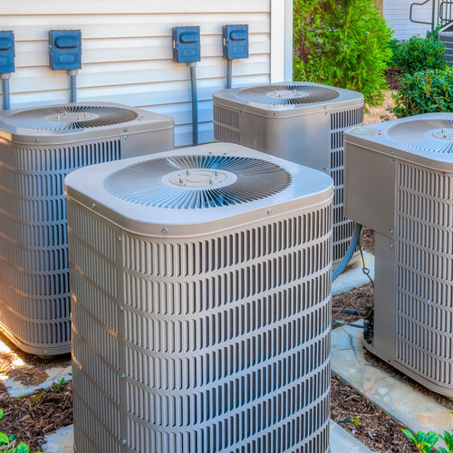 four air conditioner units outside an apartment building
