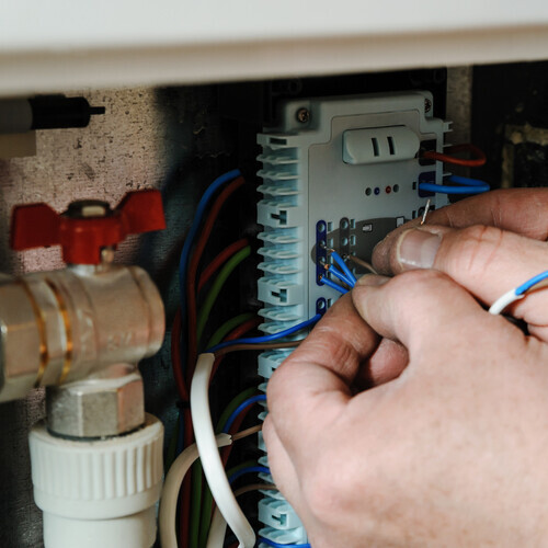 close-up of wires in an electric furnace being worked on