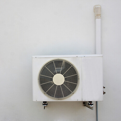 air conditioning unit installed against a white wall